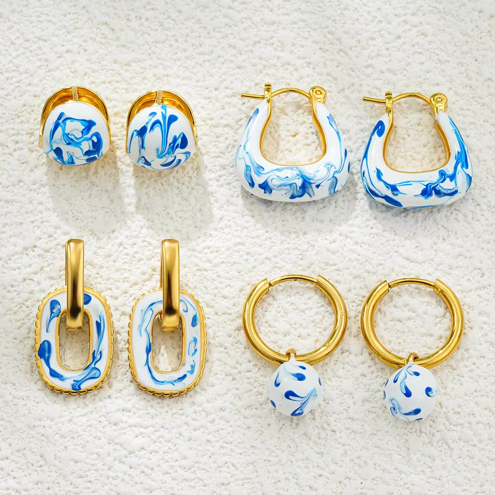 Goldene Huggie-Creolen mit weiß-blauen Emaille-Perlen, runde geometrische Form, 25 mm Höhe, elegantes Design für Damen.
