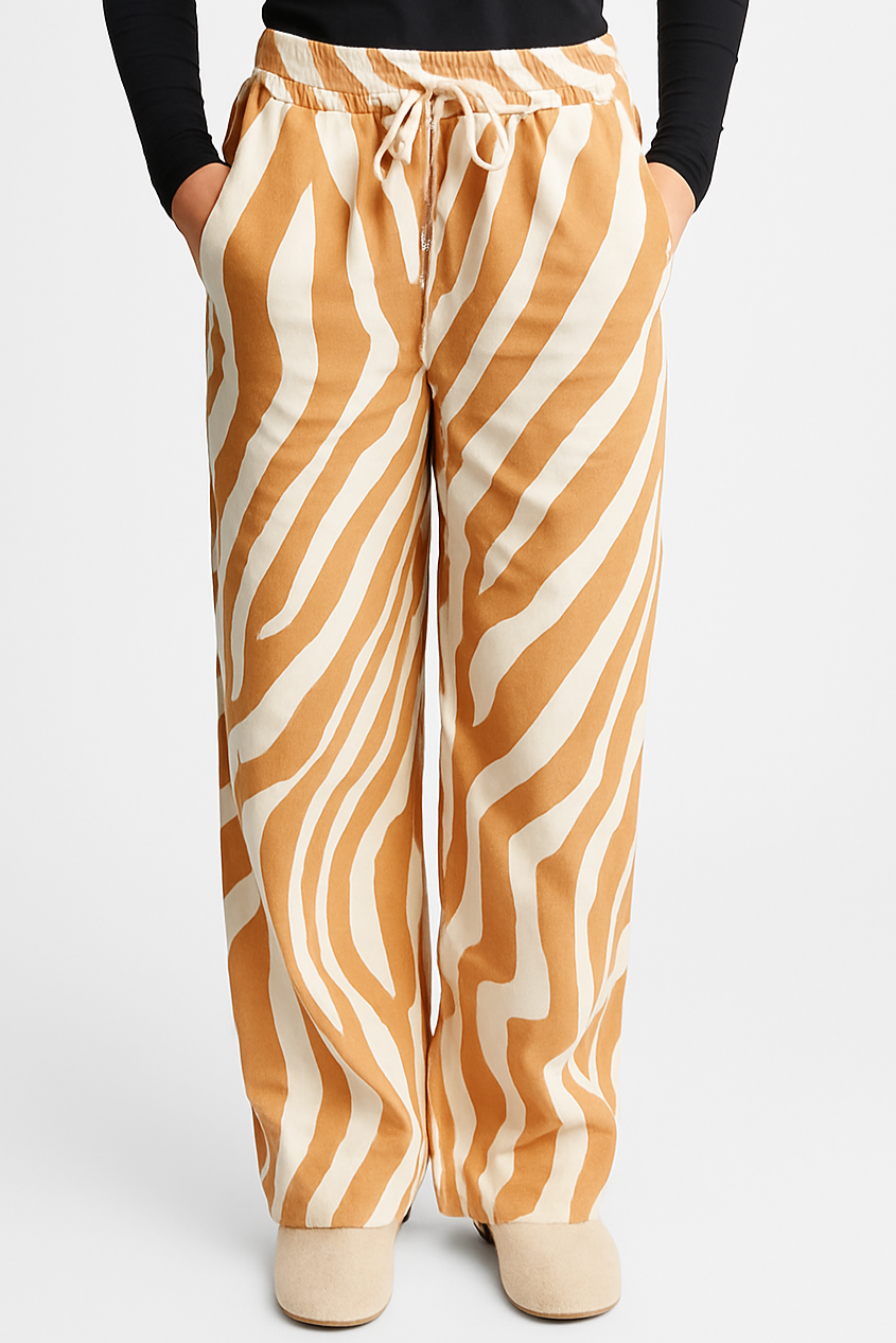 Damen Hose mit Zebra-Print in Beige und Weiß mit elastischem Bund und weitem Bein, getragen von einem Model mit schwarzem Oberteil