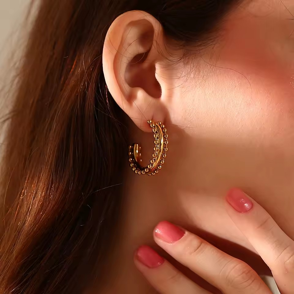 Goldene Halbcreolen mit feiner Kugelstruktur – eleganter Ohrschmuck im modernen Design.