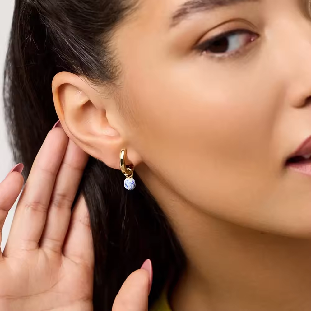 Goldene Huggie-Creolen mit weiß-blauen Emaille-Perlen, runde geometrische Form, 25 mm Höhe, elegantes Design für Damen.
