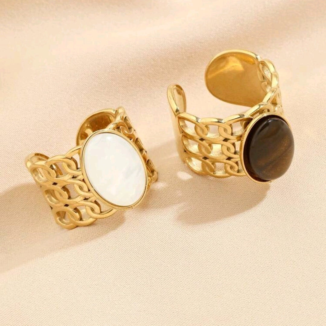 Eleganter goldener Edelstahlring mit weißem Katzenauge-Edelstein, offenes Design in moderner Optik.
