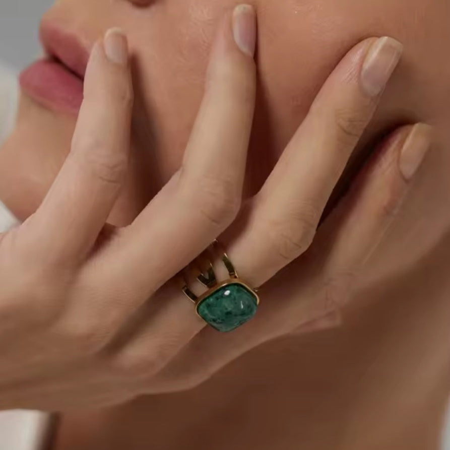 Goldener Statement-Ring aus Edelstahl mit grünem Naturstein, verstellbar, auf weißem Hintergrund.