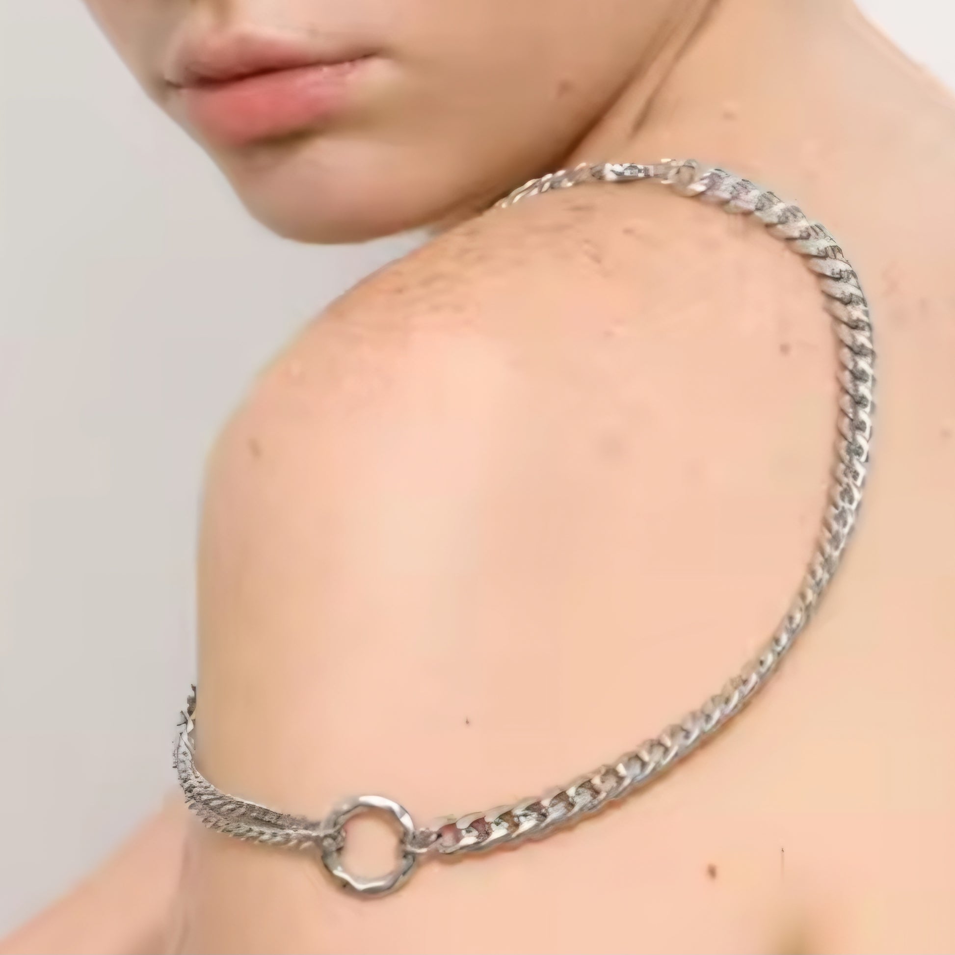 Junge Frau trägt eine moderne silberne Statement-Halskette mit Rundring-Element.