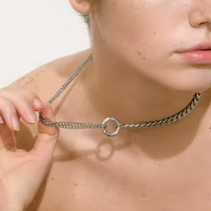 Junge Frau trägt eine moderne silberne Statement-Halskette mit Rundring-Element.