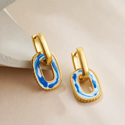 Goldene Hängeohrringe mit rechteckigem weiß-blauen Emaille-Design – einzigartiger Look für elegante Outfits.