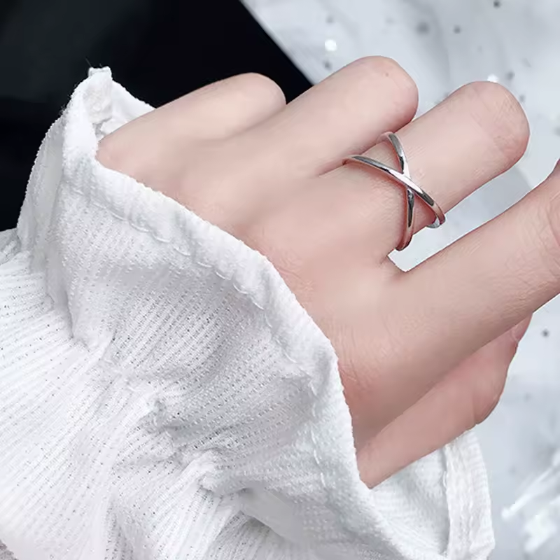 Offener Kreuzring aus 925 Silber mit glänzender Oberfläche und minimalistischem Design.