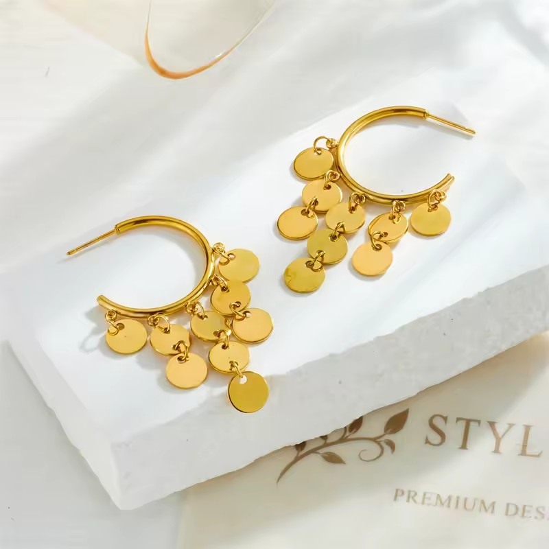 Goldene Creolen mit baumelnden runden Plättchen – stilvolle Statement-Ohrringe im Boho-Look.